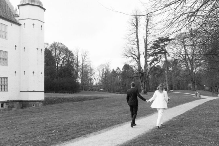Das Brautpaar spasziert durch den Park neben dem Schloss Ahrensburg und hält sich an den Händen