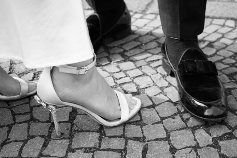 Nahaufnahme der Brautschuhe und Schuhe des Bräutigams in schwarzweiß