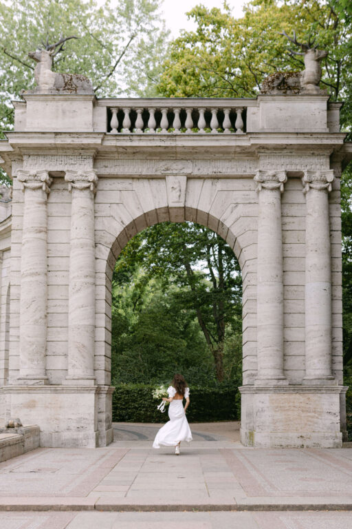 Die Hochzeitsfotografin Laura Kaiser hat sie Braut fotografiert wie sie durch ein Tor läuft.