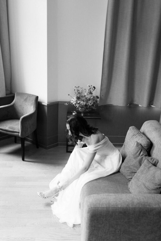 Die Braut zieht beim Getting Ready mit Hochezeitsfotografin Laura Kaiser aus Hamburg ihre Schuhe an.