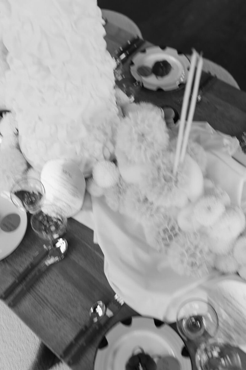 Aufwändig dekoriertes Tablesetting mit Pusteblumnen in schwarzweiß und verschwommen.