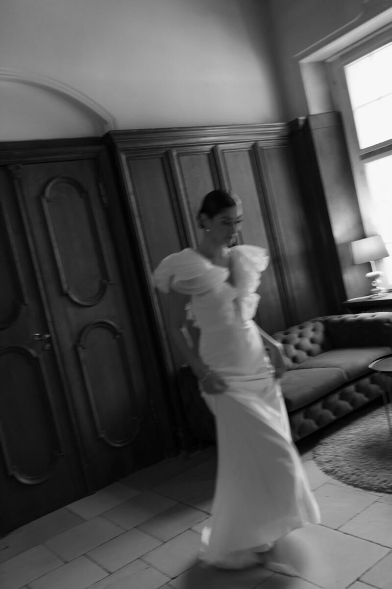 Die Braut geht schnell durch den Saal, das Bild ist leicht verschwommen.