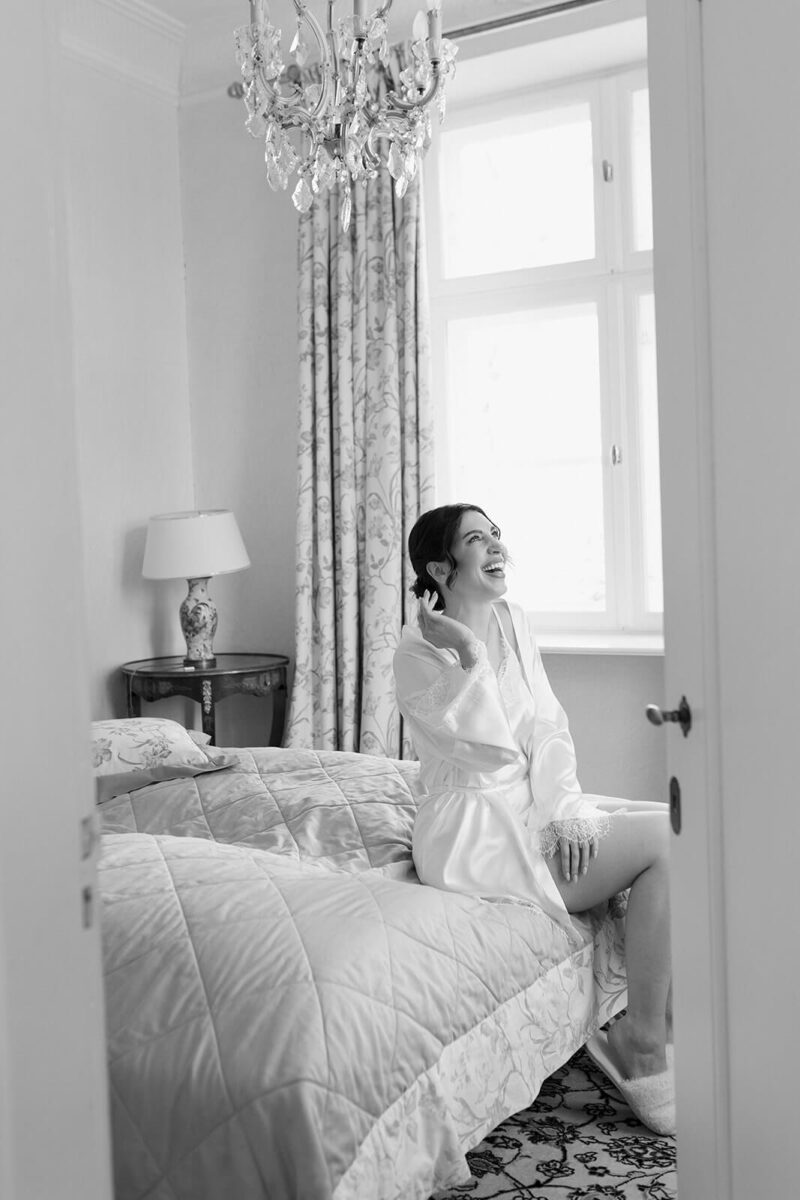 Die Braut sitzt auf dem Bett und wird dokumentarisch fotografiert.