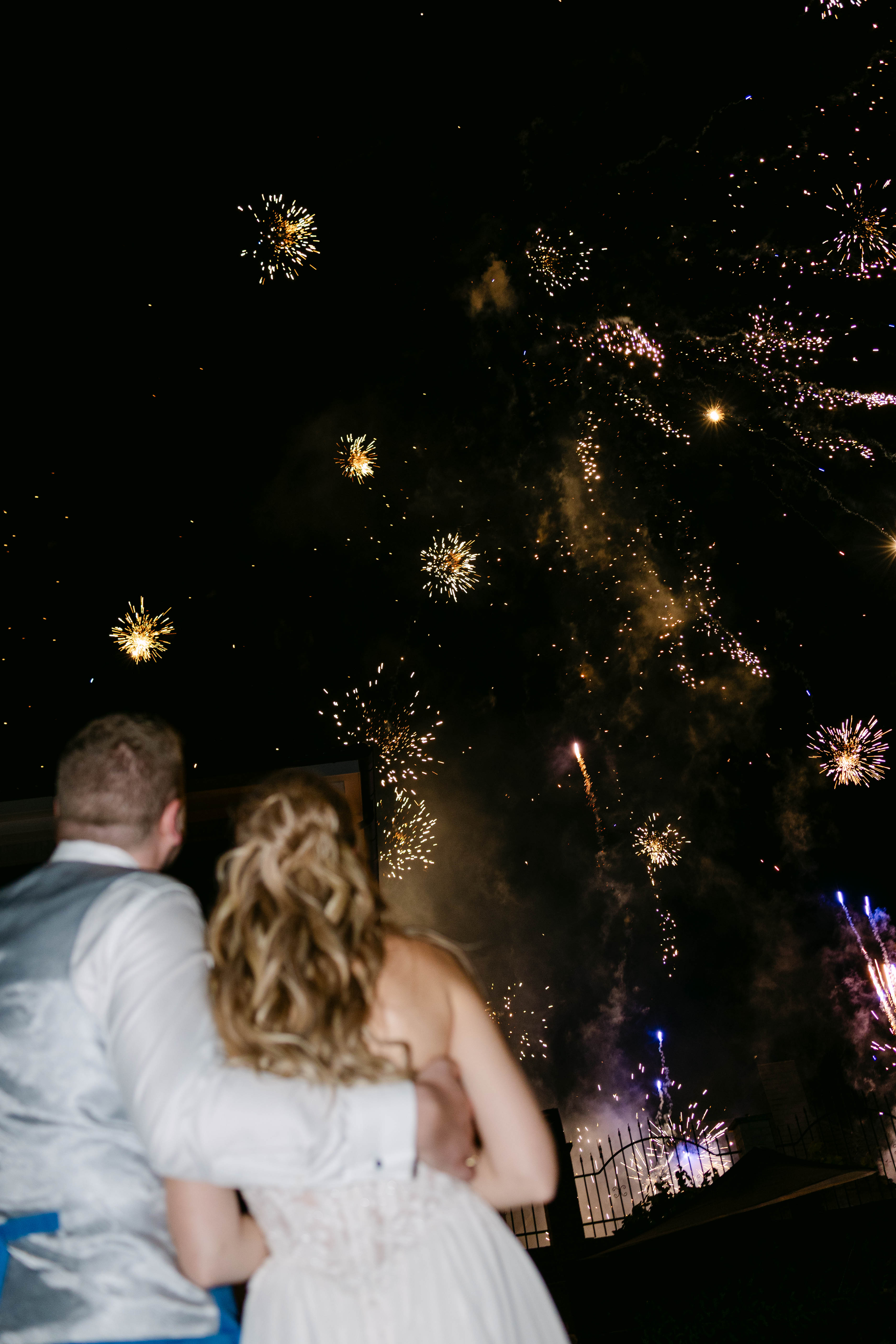 Das Brautpaar schaut sich das Feuerwerk an.
